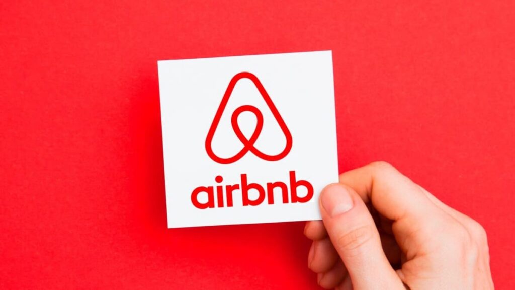 Imagen del logo de AirBNB cargado por una mano